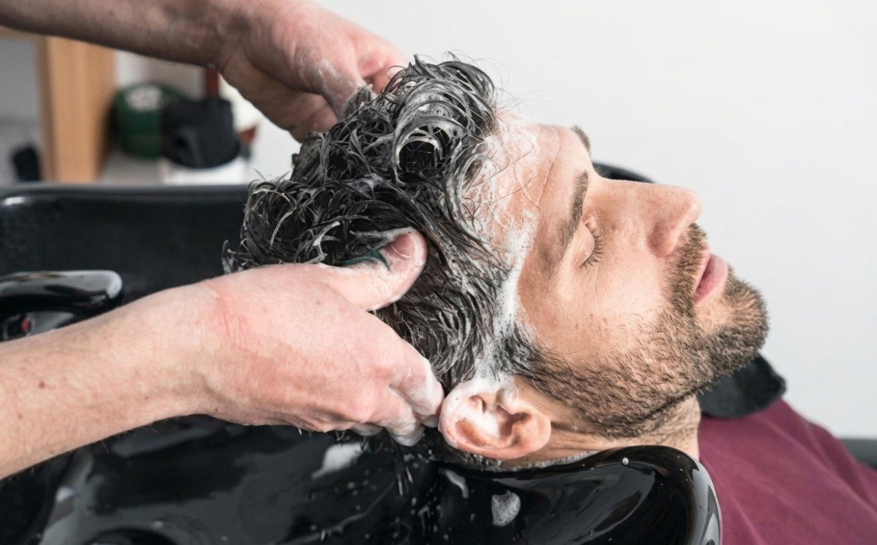 Hairdresser washing client hair in salon