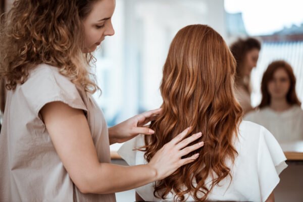 Expert hairstylist providing long hair styling and finishing touches